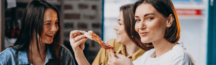 three girl friends having pizza bar